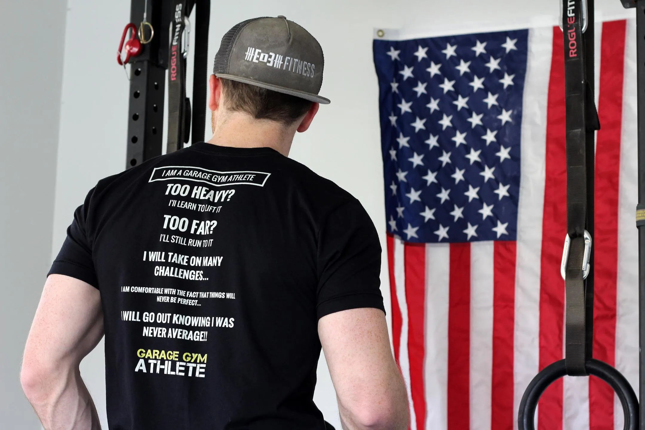 Athlete in a Garage Gym Athlete creed shirt facing a garage gym wall with an American flag