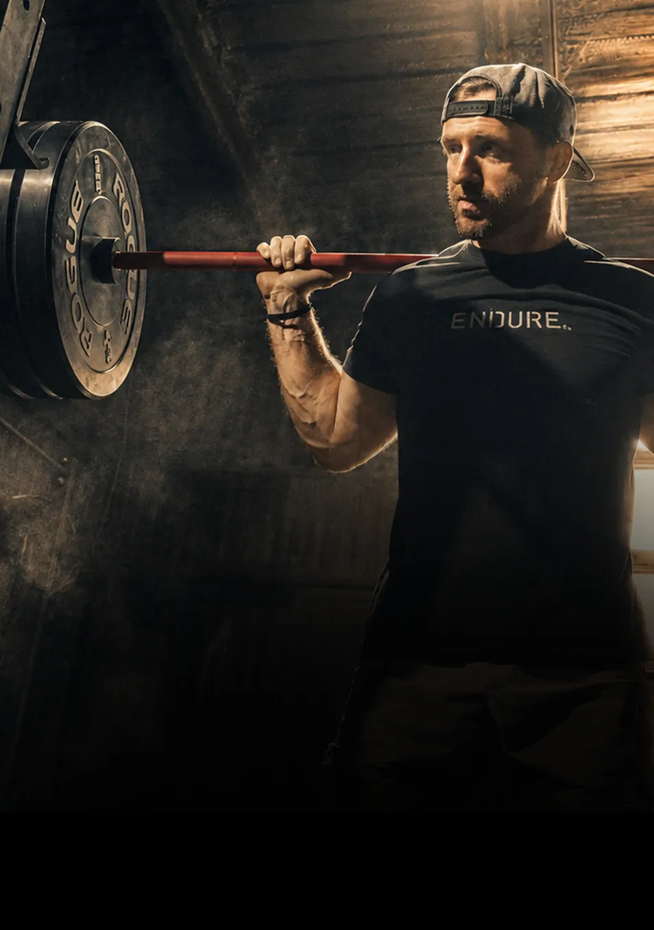 Athlete back squatting in a garage gym